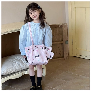 Détail du sac en toile à carreaux roses pour enfants avec motifs cartoon et mini pochette