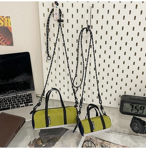 Detail showing two sizes of green nylon cylindrical crossbody bags with mesh side panels