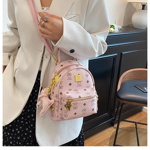 Dettaglio mini zaino rosa con motivi a orsetto e finiture dorate sulla modella