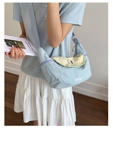Detail of light blue crossbody tote bag with white Pear print and yellow lining