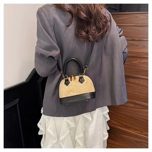 Mini sac coquille matelassé avec liseré contrasté et bandoulière réglable porté par mannequin