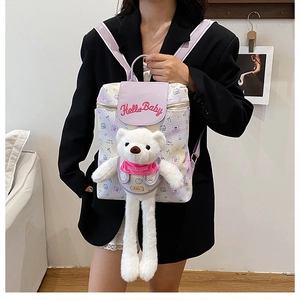 Detail of cute white backpack with 'Hello Baby' embroidery and plush bear charm