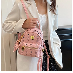 Mini zaino rosa con stampe di orsetti e dettagli dorati indossato da una modella