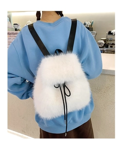 Rear view of a fluffy white faux fur backpack worn over a soft sky blue hoodie