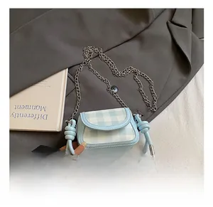 Detail view of light blue checkered mini bag with silver chain and knotted strap