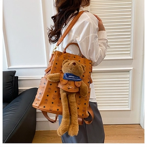 Detailansicht eines braunen Monogramm-Rucksacks mit einem großen Plüschbären-Anhänger