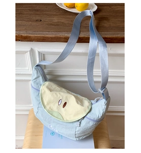 Detail of light blue nylon crescent bag featuring yellow fruit slice flap and pear embroidery