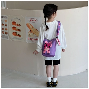 Detail view of purple canvas bucket bag with cute rabbit patch and printed strap