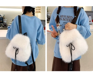Detail view of white plush faux fur mini backpack with black drawstring and slim straps