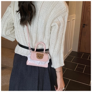 Toddler girl pink crossbody bag with plush bear and lace trim shown on a young model