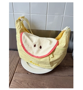 Detail of cute yellow canvas bag with apple slice design and cat paw zipper pull
