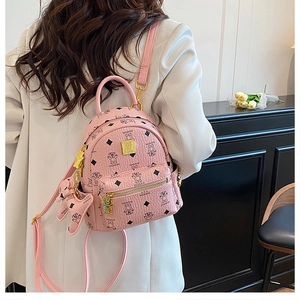 Dettaglio mini zaino rosa con motivi di orsi e logo dorato indossato da una modella