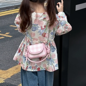 Detailed back view of a pink plaid mini crossbody bag with a magnetic flap on a child model