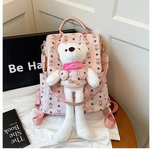 Detailansicht eines rosa PU-Rucksacks mit Bärenmuster und einem großen Plüschbären-Anhänger