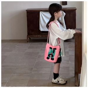 Close-up of pink canvas toddler bucket bag with cute cartoon panda print and strap