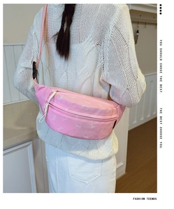 Close-up of pink chest bag with bow pattern and slogan showing strap and buckle detail