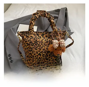 Leopard print tote bag detail showing textured fabric and cute plush bear charm accessory