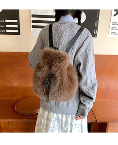Detail of plush brown faux fur backpack featuring a drawstring closure and black straps