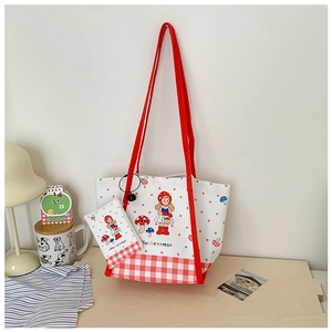Vue détaillée du sac cabas en toile blanche avec anses rouges et motifs de champignons mignons