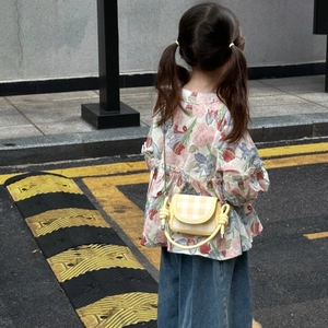 Detailed view of mini yellow plaid crossbody bag with chain strap on a child model