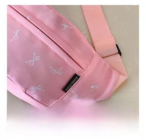 Close-up of pink crossbody bag stitching and cute white bow print pattern on canvas