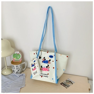 Détail du sac cabas en toile et sa mini pochette avec un dessin de chiot mignon