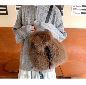 Detailed view of the brown faux fur texture and black drawstring closure on bucket bag