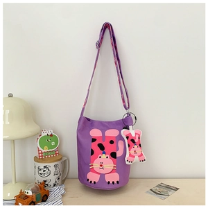 Detail of purple canvas bucket bag featuring cartoon cat motif and adjustable strap