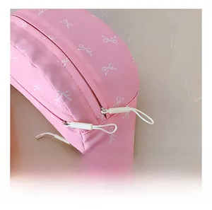 Detail of smooth dual zipper closure on pink bow-print crossbody chest bag for children