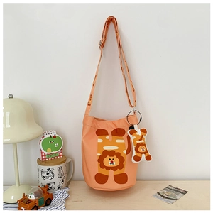 Detail of orange canvas bucket bag for kids with lion print and matching small pouch charm