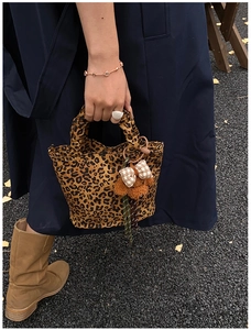 Détail du sac à main léopard en toile avec un adorable porte-clé d'ours en peluche