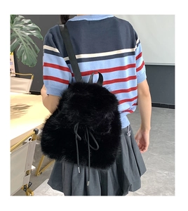 Rear view of fuzzy black faux fur backpack with drawstring on a female model