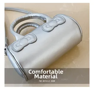 Detailed macro view of silver metallic cylindrical bag showing fine leather texture