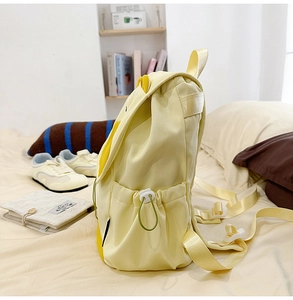 Détail de la poche latérale du sac à dos avec cordon et boucle de sangle réglable blanche