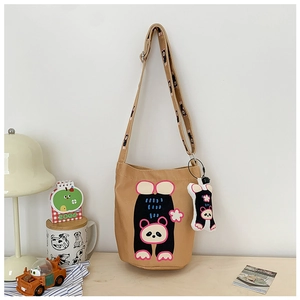 Detail of khaki canvas bucket bag with cute panda print and matching bear plush charm