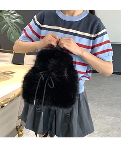 Detail of soft black faux fur backpack with adjustable straps and drawstring closure