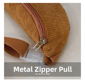 Détail du sac banane en velours côtelé montrant le zip en métal et la boucle plastique