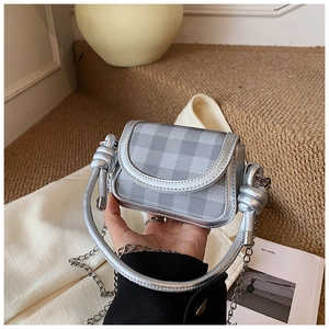 Detailed view of mini silver checkered bag featuring a thick knotted handle held in hand