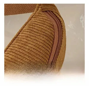 Gros plan sur la texture velours côtelé caramel et le zip assorti de ce sac banane