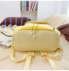 Vue détaillée du sac à dos de vache jaune avec coutures contrastées et tissu en nylon