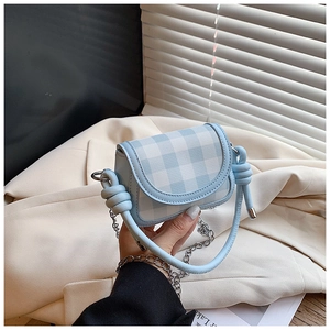 Detail of blue plaid mini crossbody bag featuring a unique knotted leather handle and chain