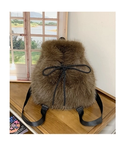 Close-up of brown plush backpack featuring fuzzy faux fur texture and black drawstring bow