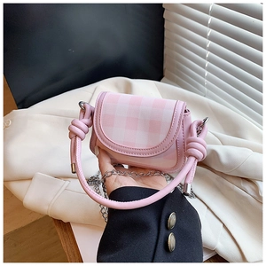 Detail of a pink plaid mini crossbody bag with a knot handle and silver metal chain