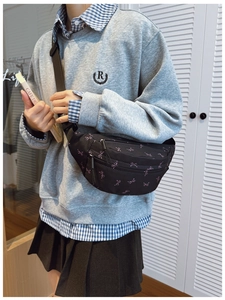 Girl wearing black waist bag with pink bow pattern and adjustable nylon strap