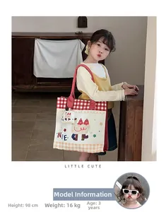 Close-up of cute cartoon canvas tote bag with red gingham pattern for little girls
