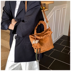 Détail du sac seau en suédine avec poignée à volants et breloque petit chien