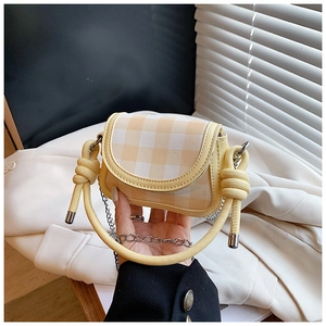 Detail of yellow plaid mini bag with knotted handle and silver chain shoulder strap