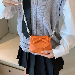 Mini orange crossbody bag for girls with bow detail and pearl handle strap