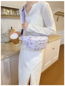 Close-up of kids light purple waist bag with bow print and adjustable shoulder strap