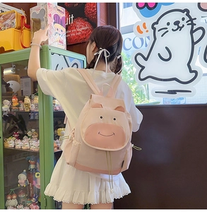 Sac à dos vache rose avec oreilles et poches à cordon porté par un modèle